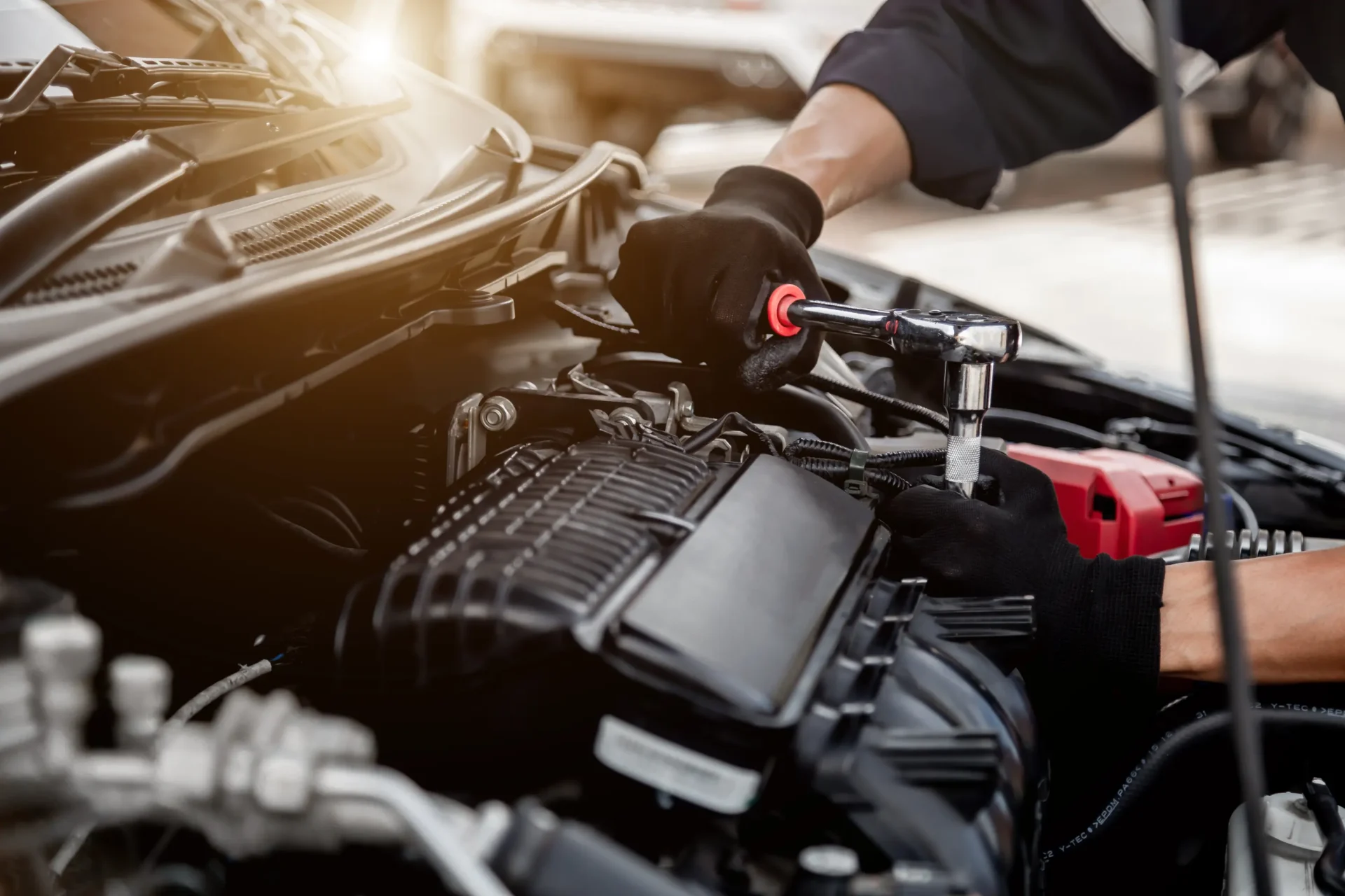 Mechanic repairing car engine with wrench.